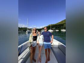 A family enjoys a sunny day on a boat, capturing a memorable moment with the beautiful marina backdrop — perfect for family outings and adventures on the water.