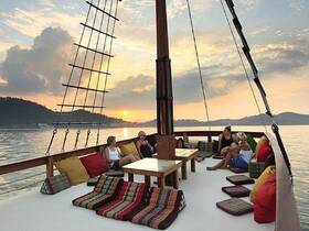 A group of friends relaxes on the deck of a boat at sunset, enjoying the serene views and comfortable seating — perfect for a memorable evening on the water.