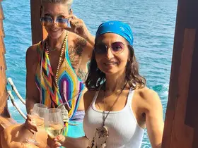 Two friends enjoy cocktails on a boat, capturing the essence of a fun-filled day at sea — perfect for celebrations and memorable outings.