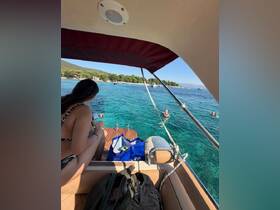 A group enjoys a refreshing swim in crystal-clear waters while relaxing on a boat, capturing the essence of a perfect summer day on the water.