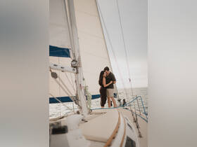 A couple shares a romantic moment aboard a sailboat, perfect for sunset cruises and intimate sailing experiences.