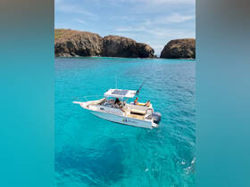 An aerial view of a fishing boat surrounded by stunning turquoise waters, showcasing a group enjoying their time on the water — perfect for adventure seekers and fishing enthusiasts.