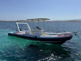 A sleek speedboat anchored in clear turquoise waters, showcasing its vibrant design against a picturesque coastal backdrop.