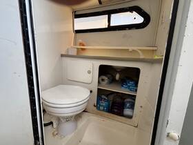 Interior view of a boat bathroom featuring a toilet and storage area, showcasing the essential amenities for comfort on the water.