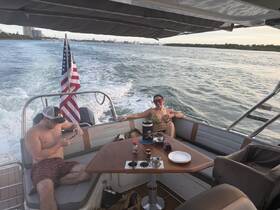 A couple enjoys a relaxing day on a boat, soaking up the sun and taking in the scenic views — perfect for a fun day on the water.