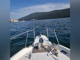 A clear view from the front of a boat cruising through calm waters, showcasing the beautiful landscape and other vessels in the background.