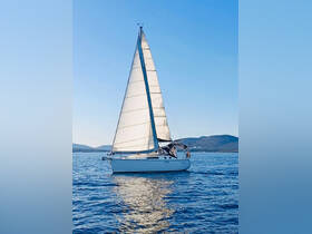 A beautiful sailboat glides through calm waters, showcasing its elegant sails against a clear blue sky — perfect for sailing enthusiasts and adventure seekers.