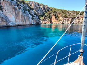 A stunning view of crystal-clear waters and rocky cliffs, showcasing the natural beauty of the coastline — perfect for exploring by boat.