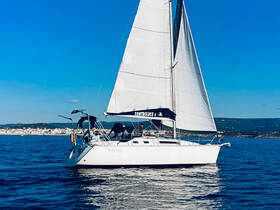 A beautiful sailboat glides through the water, showcasing its elegant design and sails against a clear blue sky — perfect for sailing enthusiasts and adventure seekers.