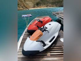 Two jet skis are docked on a wooden platform, ready for adventure in the turquoise waters — perfect for thrilling water sports activities.