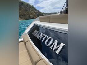 A close-up view of the 'PHANTOM' yacht showcasing its sleek design against a backdrop of turquoise waters and rocky cliffs, perfect for luxury boating experiences.