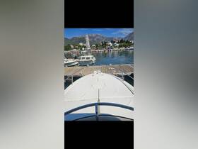 A clear view of the front of a yacht docked at a marina, showcasing the surrounding scenic landscape and calm waters.