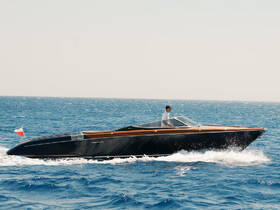 A sleek speedboat glides through the open water, showcasing a stylish design and a skilled driver at the helm — perfect for thrilling adventures on the sea.