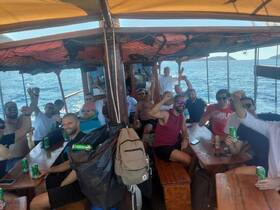 A lively group of friends celebrates aboard a boat, enjoying drinks and camaraderie on the open water — perfect for party outings and memorable adventures.