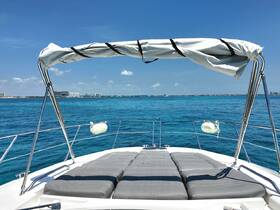 A stunning view from the bow of a yacht, showcasing comfortable seating and the vibrant turquoise waters, perfect for a relaxing day on the water.