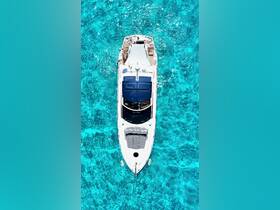 A stunning aerial view of a yacht cruising through crystal-clear turquoise waters, showcasing its sleek design and inviting deck space.