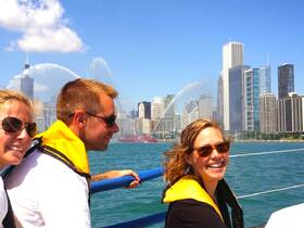 A joyful group enjoys a boat ride with the stunning Chicago skyline in the background, capturing the essence of summer fun on the water.