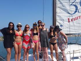 A lively group of friends poses together on a sailboat, enjoying a sunny day on the water — perfect for celebrations and memorable outings.