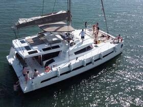 A lively group enjoys a day on a catamaran, with guests swimming and relaxing on deck — perfect for summer parties and fun on the water.