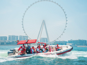 A lively group enjoys a thrilling ride on a speedboat in Dubai, with the iconic Ferris wheel in the background — perfect for adventure seekers and sightseeing.