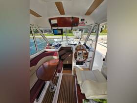 The interior of a boat's helm area showcases a well-equipped console and comfortable seating, perfect for navigating the waters in style.