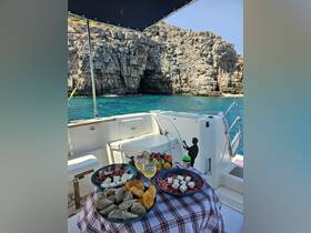 A beautifully arranged spread of snacks and drinks on a boat, perfect for enjoying a relaxing day on the water surrounded by stunning coastal scenery.