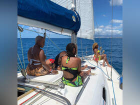 A group of friends enjoys a sunny day sailing on a yacht, capturing the essence of relaxation and camaraderie on the water.