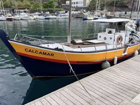 A vibrant view of the CALCAMAR boat docked at the marina, showcasing its colorful hull and serene surroundings.