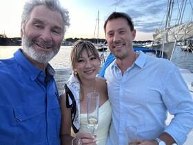 A joyful group celebrates with cocktails at sunset, capturing a memorable moment on the water — perfect for special occasions and gatherings.