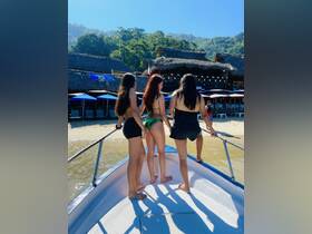 A group of friends enjoys a sunny day on a boat, ready for a beach adventure — perfect for summer outings and fun on the water.