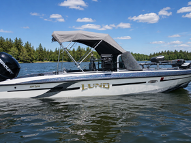 A sleek Lund boat is docked on calm waters, showcasing its stylish design and features, perfect for fishing or leisure outings.