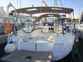 A detailed view of the helm area inside a sleek sailboat, showcasing the modern console and spacious cabin design, perfect for comfortable sailing experiences.