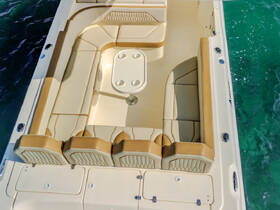 A spacious and elegantly designed interior seating area of a boat, featuring plush cushions and a central table, perfect for relaxing while enjoying the water.