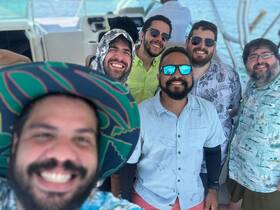 A cheerful group of friends poses for a selfie aboard a boat, capturing the fun and camaraderie of their day on the water.