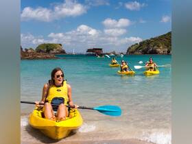A group of friends enjoys a fun kayaking adventure in clear turquoise waters, perfect for beach outings and water sports.