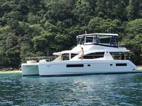 A young girl enjoys the deck of a Leopard 51 catamaran, anchored near a beautiful beach, showcasing the perfect blend of relaxation and adventure on the water.