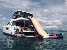 A lively group enjoys a fun day on the water with a water slide attached to their boat, perfect for summer adventures and family outings.
