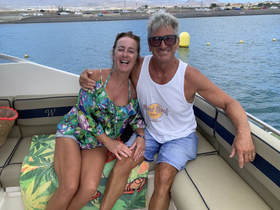 A joyful couple enjoys their time on a boat, showcasing smiles and a relaxed atmosphere — perfect for romantic getaways or fun outings on the water.