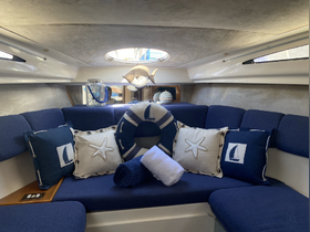 Cozy interior of a boat cabin featuring nautical-themed cushions and a relaxing lounge area, perfect for unwinding during a sailing trip.