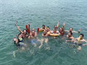 A lively group enjoys a fun day swimming in the water, showcasing family bonding and celebration under the sun.