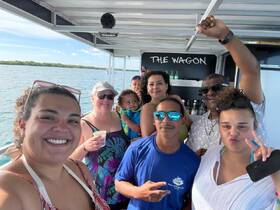 A joyful group enjoys a fun moment aboard a boat, capturing the essence of celebration and togetherness on the water.