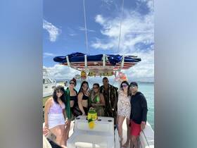 A lively group celebrates a birthday aboard a boat, complete with a festive cake and decorations — perfect for memorable celebrations on the water.