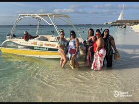 A lively group enjoys a day at the beach with a private boat, perfect for snorkeling tours and memorable celebrations under the sun.