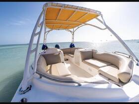 A spacious interior view of a boat featuring comfortable seating and a helm, perfect for relaxing on the water.