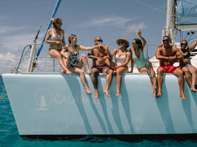 A lively group of friends enjoys drinks on the deck of a yacht, celebrating together under the sun — perfect for memorable outings on the water.