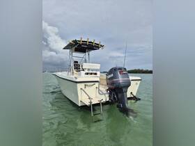 A sleek center console boat captured from the back, showcasing its design and motor in clear waters — perfect for fishing or day trips.