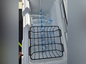 A well-stocked cooler filled with bottled water, perfect for staying hydrated during a day on the water.