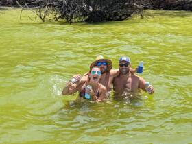 A lively group enjoys a fun day in the water, celebrating with drinks and laughter — perfect for summer adventures and memorable outings.