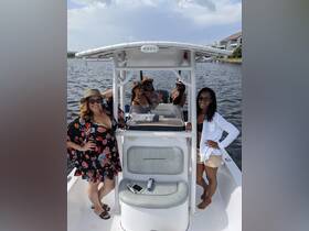 A lively group of friends enjoys a fun day on the water, showcasing camaraderie and celebration aboard their boat.