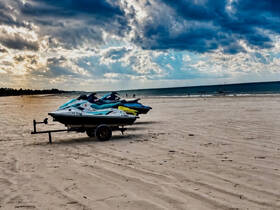 A lineup of jet skis parked on the beach, ready for thrilling water sports adventures. Perfect for those looking to enjoy a day of fun on the water.